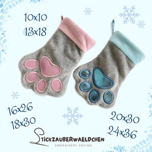 Könnte beinhalten: Zwei graue Weihnachtsstrümpfe mit rosa und blauen Pfotenabdruck-Stickereien. Die Strümpfe haben eine flauschige Textur und sind in den Größen 10x10, 13x18, 16x26, 18x30, 20x30 und 24x36 erhältlich. Der Text "Stickzauberwaeldchen Embroidery Design" befindet sich am unteren Rand des Bildes.