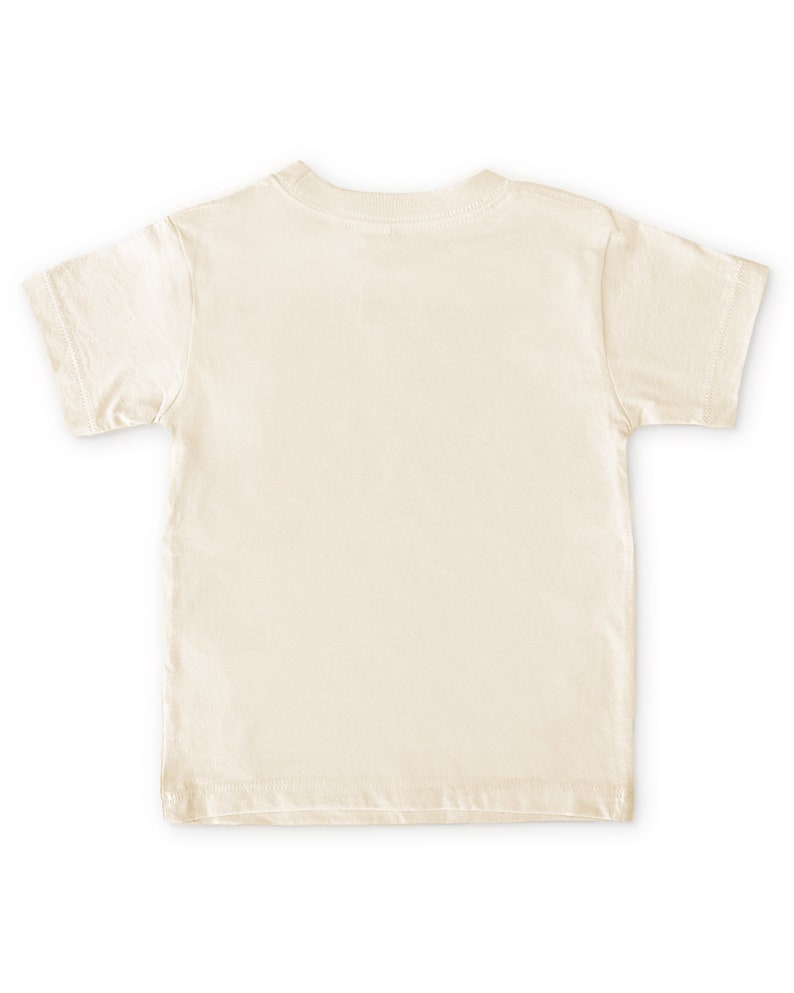 Back view of short sleeve natural white toddler crew neck tee laying flat on white background