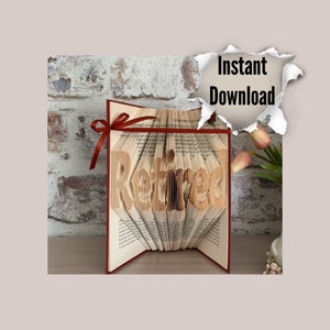May include: A book art sculpture with the word "Retired" spelled out in folded pages. The book is open and standing upright on a table. The book has a red ribbon tied around it.