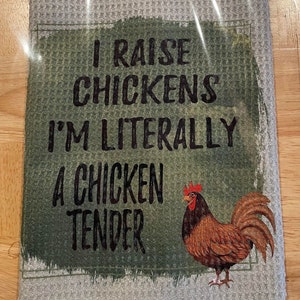 Peut inclure: Une serviette de cuisine verte et blanche avec le texte "I raise chickens I'm literally a chicken tender" et une image de dessin animé d'un coq.