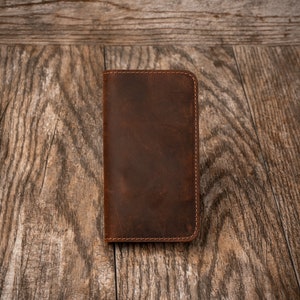 May include: A brown leather wallet with a stitched edge.