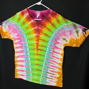 May include: A tie-dye t-shirt with a vibrant color scheme, featuring shades of orange, yellow, green, blue, pink, and red. The shirt has a unique swirl pattern and a relaxed fit.