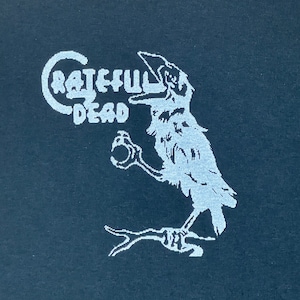 May include: A black t-shirt with a white graphic of a crow singing "Grateful Dead" on a branch.