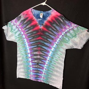 May include: A tie-dye t-shirt with a blue, green, purple, and red colour scheme. The shirt has a V-shaped design in the centre.