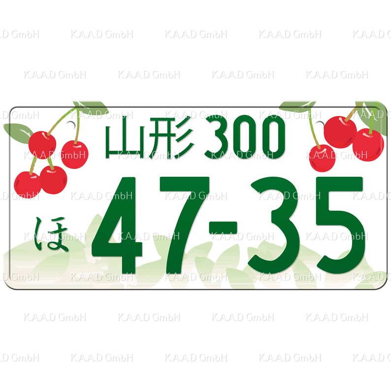 Puede incluir: Un letrero rectangular blanco con texto y n&uacute;meros verdes. El letrero dice "山形 300 ほ 47-35". El letrero est&aacute; decorado con cerezas rojas y hojas verdes.