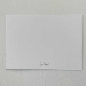 Puede incluir: Una tarjeta blanca con una superficie texturizada, con una firma y el texto "fine art design" en escritura negra en la parte inferior. La tarjeta est&aacute; centrada sobre un fondo blanco.