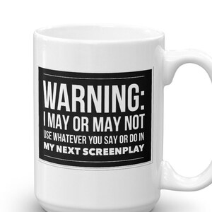 May include: White ceramic coffee mug with a black warning sign that reads "WARNING: I MAY OR MAY NOT USE WHATEVER YOU SAY OR DO IN MY NEXT SCREENPLAY".