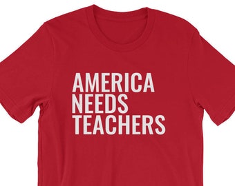 May include: Red short-sleeved t-shirt with white text that reads "AMERICA NEEDS TEACHERS".