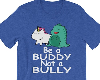 May include: Blue t-shirt with a white unicorn and green dinosaur graphic. The text "Be a Buddy Not a Bully" is printed in white below the graphic.