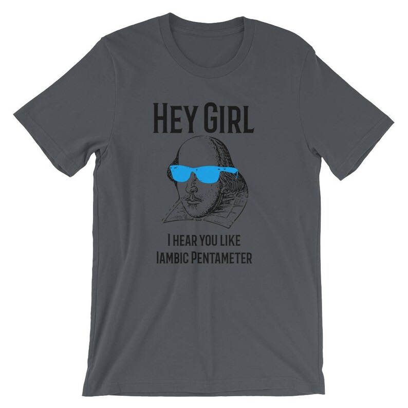 May include: A dark gray t-shirt with a black and white illustration of William Shakespeare wearing blue sunglasses. The text "HEY GIRL" is above the illustration and the text "I HEAR YOU LIKE IAMBIC PENTAMETER" is below the illustration.