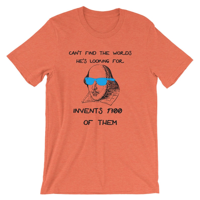 May include: A coral orange t-shirt with a black and white illustration of William Shakespeare wearing blue sunglasses. The text "Can't find the words he's looking for. Invents 1700 of them." is printed on the shirt.