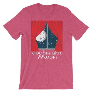 May include: A pink t-shirt with a graphic of a window with red curtains and a full moon in the night sky. The text "GOODNIGHT MOON" is printed below the window.