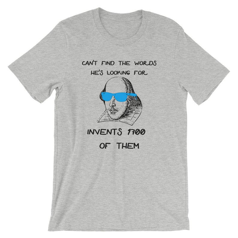 May include: A gray t-shirt with a black and white illustration of William Shakespeare wearing blue sunglasses. The text on the shirt reads "Can't find the words he's looking for. Invents 1700 of them."