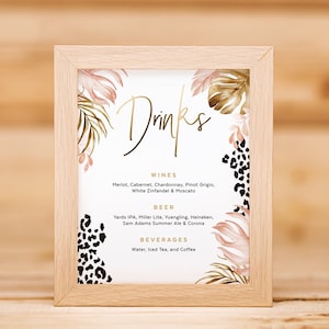 May include: A framed sign with a tropical theme, featuring a gold inscription that reads "Drinks". The sign lists various wine, beer, and beverage options. The background features a watercolour design of tropical leaves and animal print.
