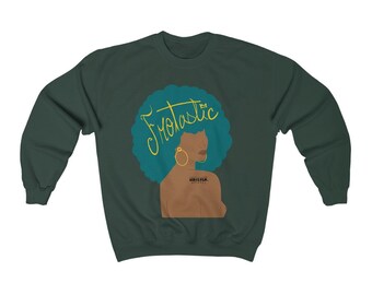 May include: Dark green sweatshirt featuring a graphic of a woman with teal hair and gold hoop earrings. The word "Frotastic" is written in yellow script above the woman's head. The sweatshirt also has the text "WHATEVER" on the woman's shoulder.