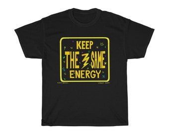 May include: Black t-shirt with a yellow-bordered rectangle containing the text "KEEP THE SAME ENERGY" in yellow and white. A lightning bolt graphic is in the center. Small colorful doodles surround the text.