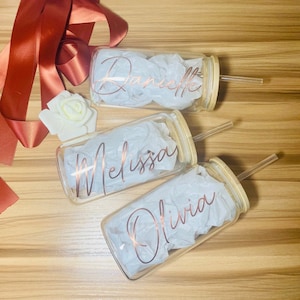 May include: Three glass tumblers with bamboo lids and clear straws. Each tumbler has a different name written in gold lettering: Danielle, Melissa, and Olivia.