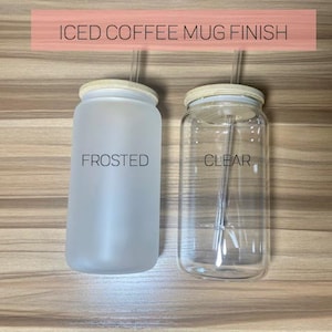 May include: Two iced coffee mugs with lids and straws. The mug on the left is frosted and the mug on the right is clear. The text "FROSTED" is printed on the frosted mug and the text "CLEAR" is printed on the clear mug.