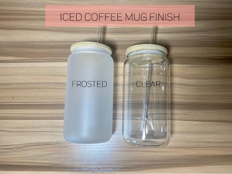 May include: Two iced coffee mugs with lids and straws. The mug on the left is frosted and the mug on the right is clear. The text "FROSTED" is printed on the frosted mug and the text "CLEAR" is printed on the clear mug.