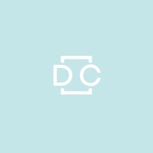 Puede incluir: Un logotipo blanco con las letras "DC" dentro de un cuadrado sobre un fondo azul claro.