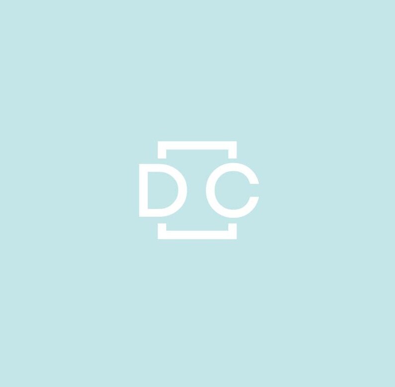 May include: A white logo with the letters "DC" inside a square on a light blue background.