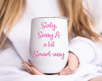 May include: White stainless steel tumbler with a pink inscription that reads "Sixty, Sassy & a bit Smart-assy".