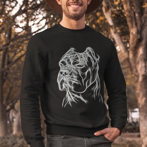 Op de afbeelding: Een zwart sweatshirt met een wit lijnontwerp van een hondenkop. De hond heeft een korte, platte snuit en grote, hangende oren.