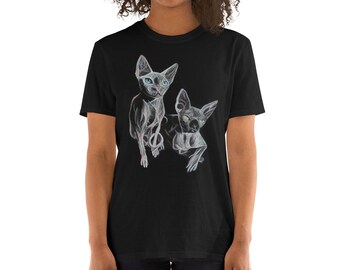 May include: Black t-shirt featuring a graphic of two hairless cats. The cats are depicted in a stylised, almost skeletal, manner. One cat is white with blue eyes, the other is black with green eyes.