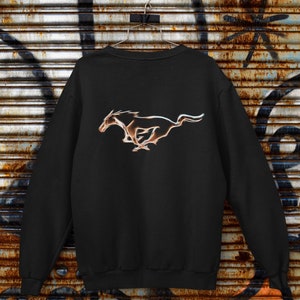 May include: Black sweatshirt with a gold-coloured Ford Mustang logo on the back.