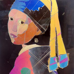 May include: A colorful, abstract portrait of a woman wearing a blue and yellow headscarf. The woman's face is made up of different colored pieces of paper, creating a mosaic effect. The background is black.
