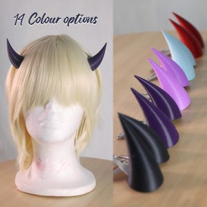 May include: 14 colour options for devil horns hair clips. The horns are made of a smooth, matte plastic and come in a variety of colours, including black, purple, blue, and red.