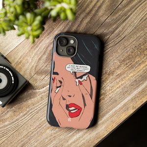 Puede incluir: Una funda negra para iPhone con una ilustración de estilo pop art de una mujer llorando. El texto en la funda dice "I may be ruining my life, but I can't help myself."