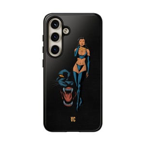 Op de afbeelding: Zwarte telefoonhoes met een afbeelding van een vrouw in een blauwe en zwarte outfit die naast een zwarte panter staat met zijn bek open. De telefoonhoes heeft een zwarte achtergrond en een gouden logo in het midden onderaan.