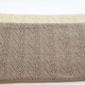May include: Two knitted blankets, one beige and one brown, with a chevron pattern. The blankets are made of a soft, lightweight material and have a delicate openwork design.