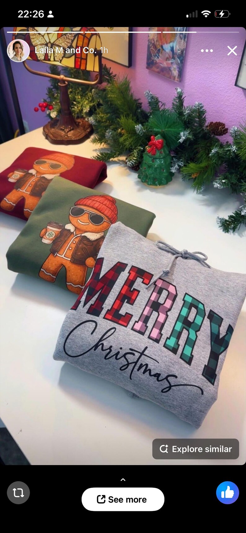 May include: Folded sweatshirts with holiday designs. One is gray with "MERRY Christmas" in plaid lettering. Another is green with a gingerbread man graphic. The third is burgundy with a gingerbread man graphic.