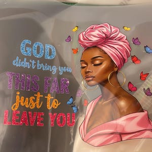 May include: Illustration of a woman with a pink head wrap and gold hoop earrings, surrounded by colorful butterflies. Text reads "GOD didn't bring you THIS FAR just to LEAVE YOU" in glittery letters.