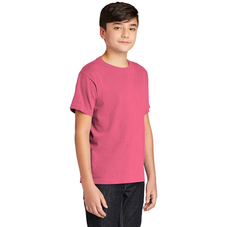 May include: A pink short-sleeved t-shirt for kids. The t-shirt has a crew neck and is made of a soft, comfortable fabric.