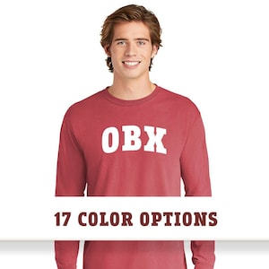 May include: A red long-sleeve t-shirt with the text "OBX" in white lettering. The shirt is available in 17 colors.