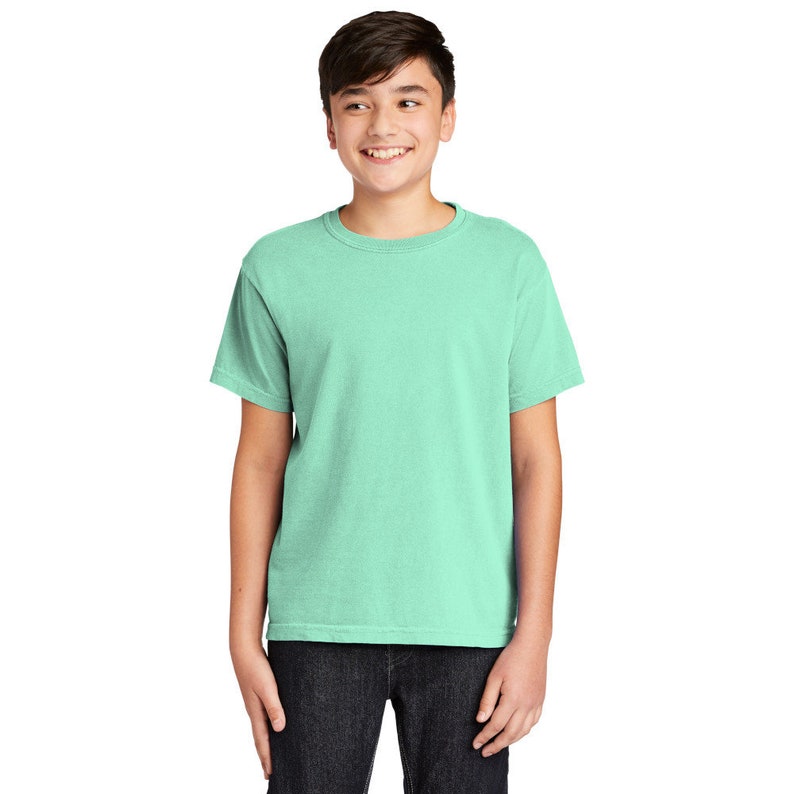 May include: A light green short-sleeved t-shirt for kids. The t-shirt has a crew neck and a relaxed fit.