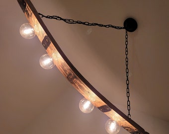 May include: A curved wooden light fixture with five light bulbs. The fixture is suspended from the ceiling by a black chain.