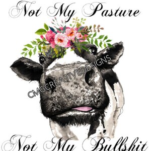 May include: A black and white cow with a pink tongue sticking out, wearing a floral crown with pink and white flowers. The cow is looking at the camera. The text "Not My Pasture Not My Bullshit" is written in black cursive lettering above and below the cow.