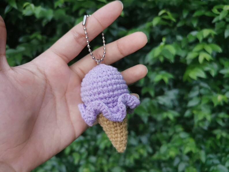 May include: A purple crocheted ice cream cone keychain with a silver chain.