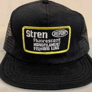 May include: Black mesh trucker hat with a yellow and white patch that reads "Stren Fluorescent Monofilament Fishing Line" and a small white oval with the word "DuPont" inside.