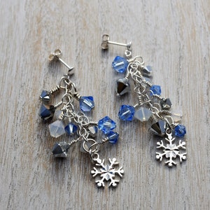 May include: Silver snowflake dangle earrings with blue and clear crystal beads.