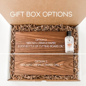 May include: A wooden cutting board in a gift box with two gift box options. Option 1 includes brown crinkle paper only. Option 2 includes brown crinkle paper and an 8 oz bottle of cutting board oil.