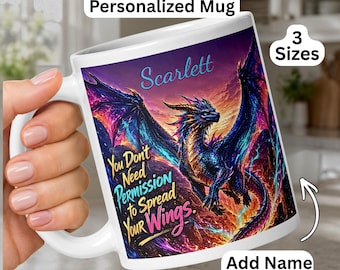 May include: A white ceramic mug featuring a colorful dragon illustration with blue, pink, and orange hues. The text reads "Scarlett" at the top and "You Don't Need Permission to Spread Your Wings." below the dragon. The mug includes text labels.