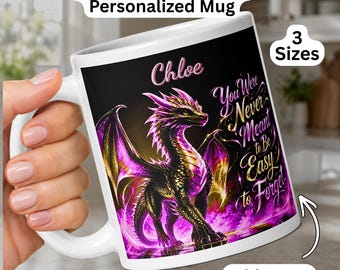 May include: A white ceramic mug featuring a graphic of a pink and golden dragon on a black background. The text reads "Chloe" and "You Were Never Meant to be Easy to Forget." The mug includes text labels "Pink & Golden Dragon Personalized Mug," "3 Sizes," and "Add Name."