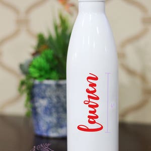 May include: White stainless steel water bottle with a red cursive name "Lauren" printed on the side. The bottle is 4 inches tall.