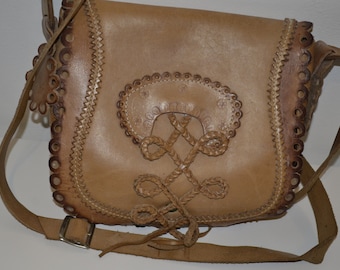 May include: A tan leather shoulder bag with a braided design and decorative stitching. The bag has a flap closure and a long adjustable strap.