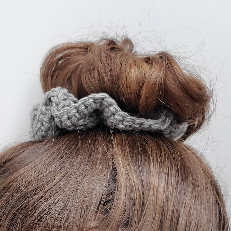May include: Gray crocheted hair scrunchie with a ruffled design.